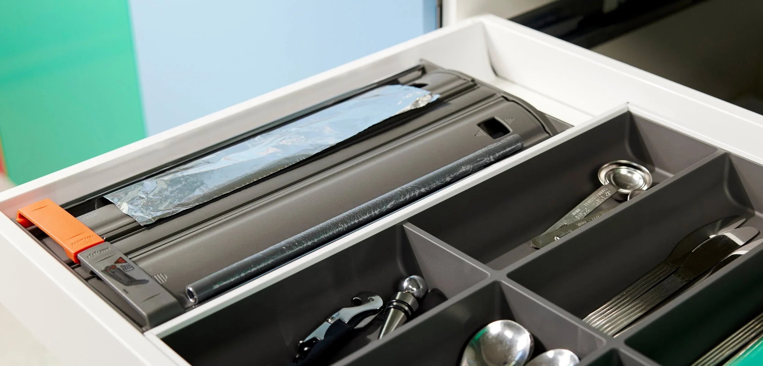 Organisierter Besteckkasten mit Folienschneider und Küchenutensilien in moderner Schublade