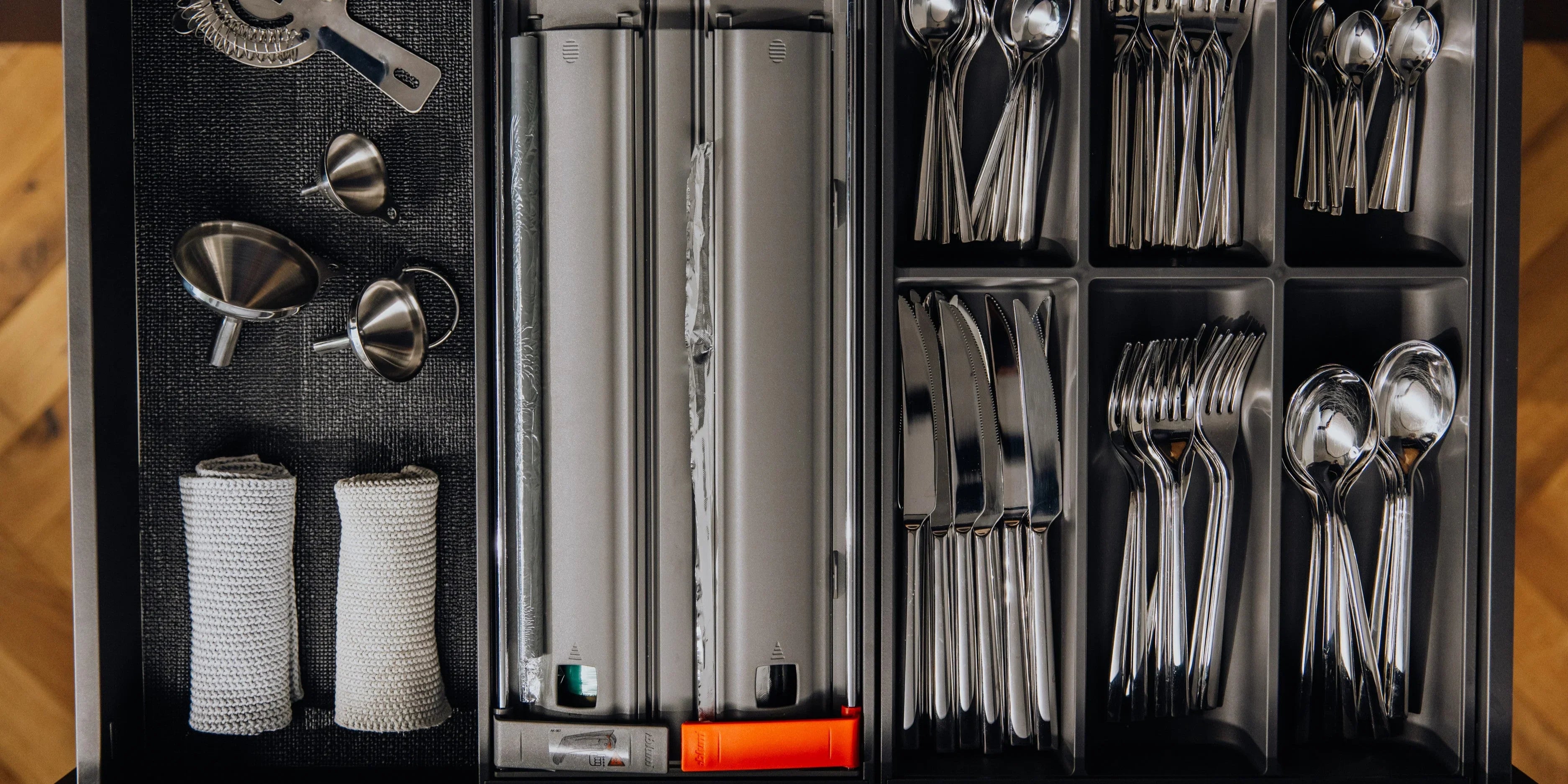 Organisierte Küchenschublade mit Besteckkasten, Folienschneider und Edelstahltrichtern